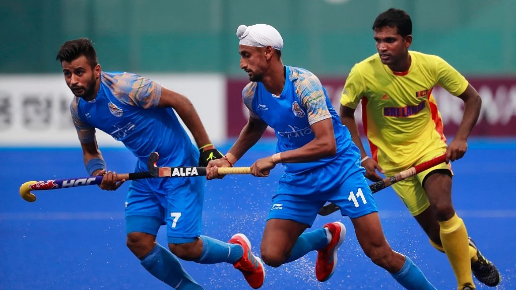 India’s Manpreet Singh, left, and Mandeep Singh, center, and Sri Lanka’s Mud IKJ Doranegala run for the ball during the Asian Games hockey men’s match.
