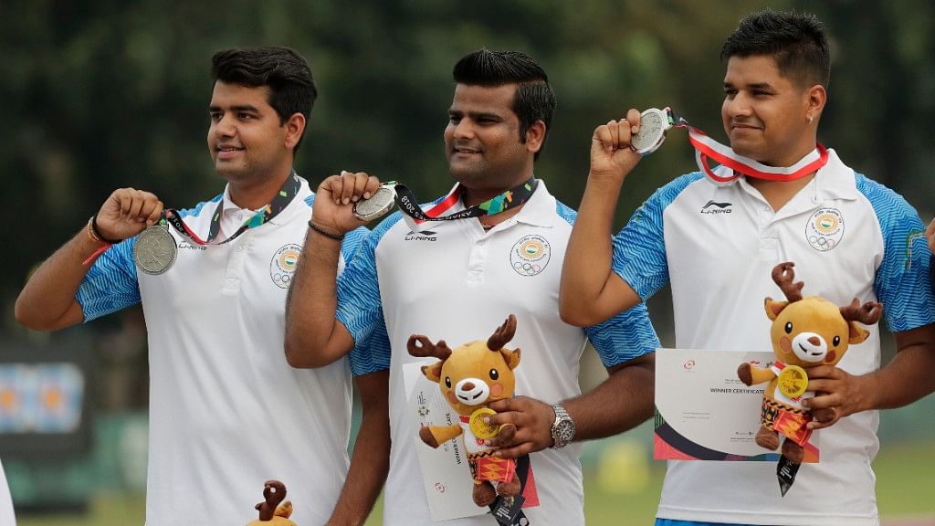 Rajat Chauhan (centre) stands on the podium after his silver medal finish at the Asian Games.