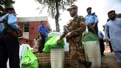 File photo of security officials guarding ballot boxes and voting materials at a distribution center in Islamabad.
