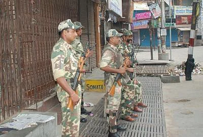 Security personnel stand guard at Muzaffarnagar as Army petrol the streets to defuse tension on Sept 9, 2013. (Photo: IANS)