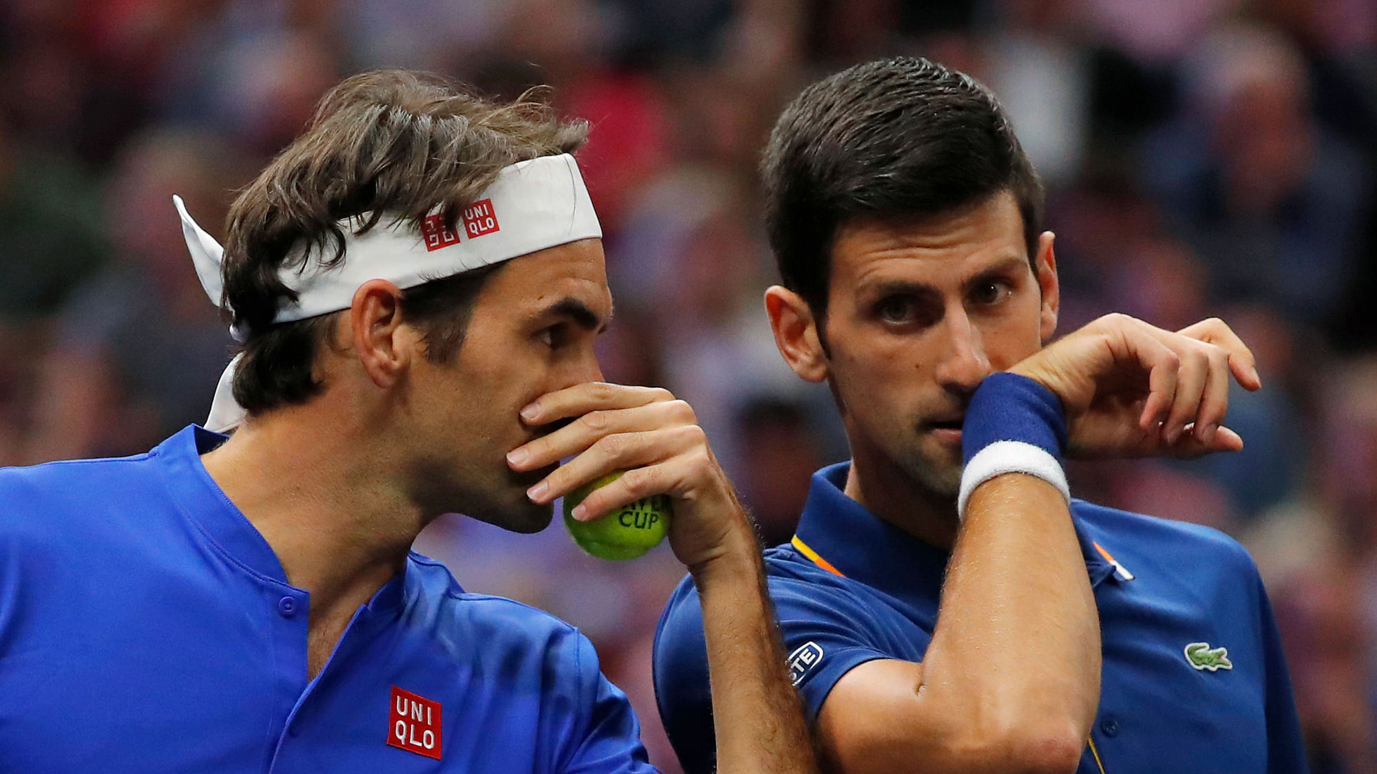 Team Europe’s Roger Federer, left, whispers to Novak Djokovic during a men’s doubles tennis match against Team World’s Jack Sock and Kevin Anderson at the Laver Cup.