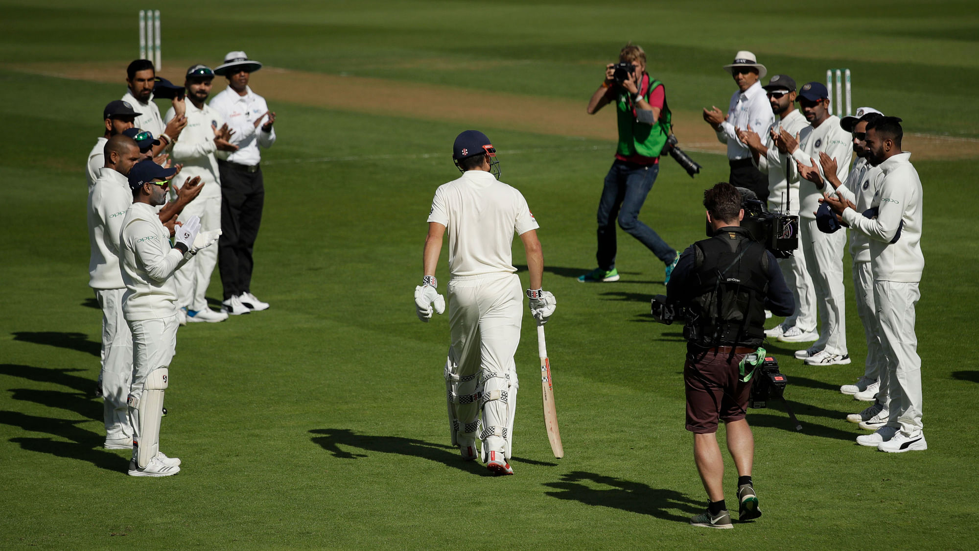 England’s Alastair Cook, center, walks out to bat in his last ever test match during the fifth Test match between England and India at the Oval cricket ground.