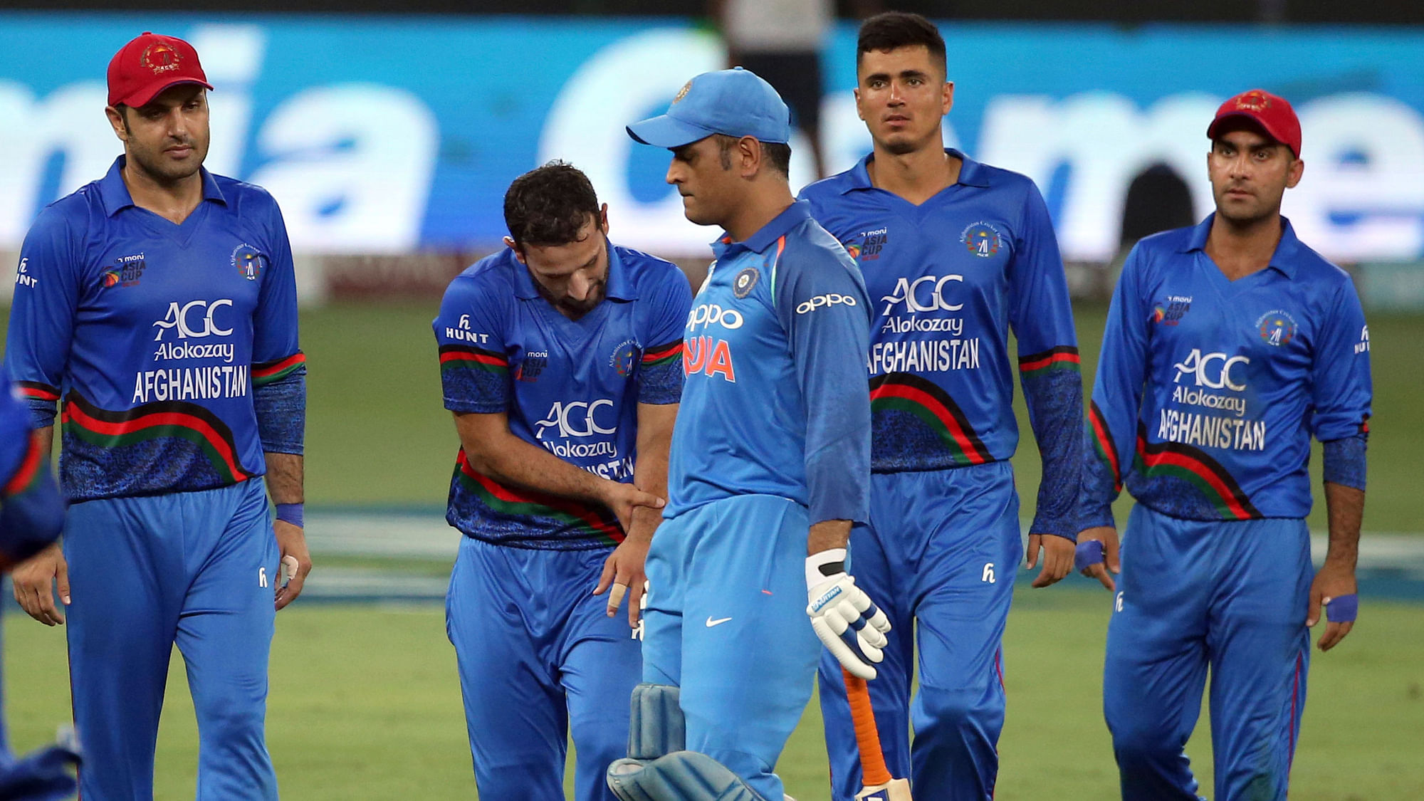 India’s Mahendra Singh Dhoni, third left, leaves the field after losing his wicket as Afghanistan’s Javed Ahmadi.