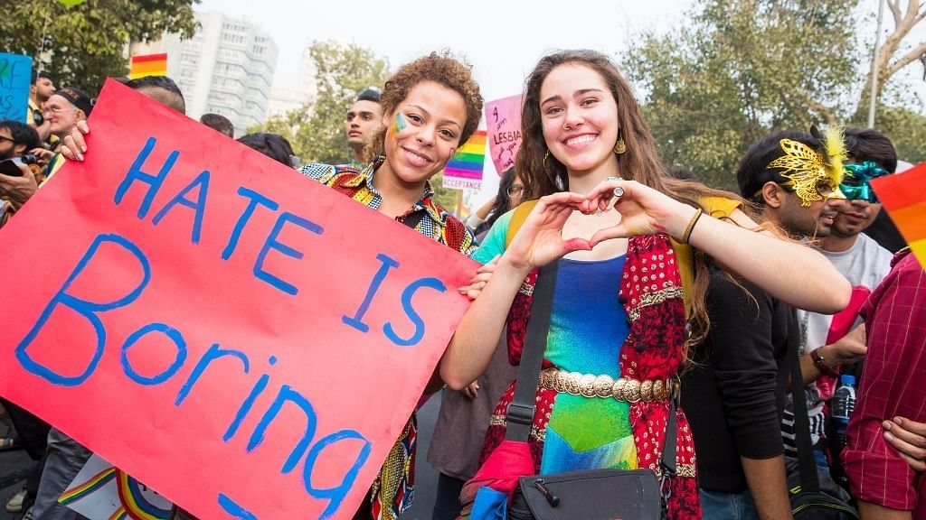 A lesbian couple celebrating Queer Pride at New Delhi, holding placards.