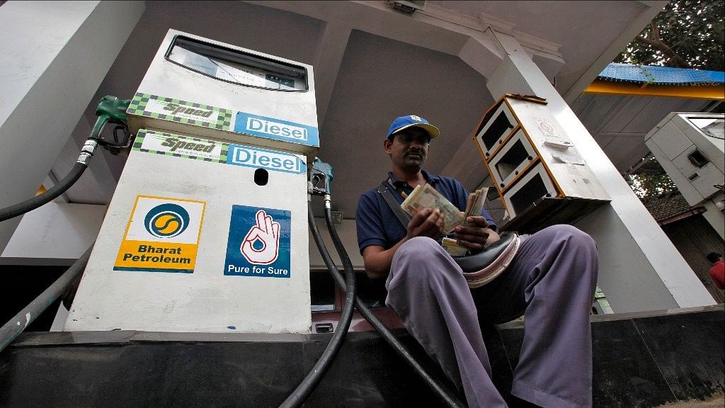 A petrol pump executive counts the cash collected from sales.