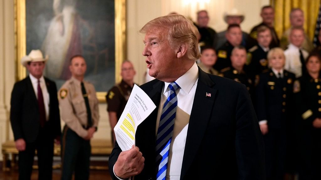 President Donald Trump responds to reporters question during an event with sheriffs in the East Room of the White House in Washington.