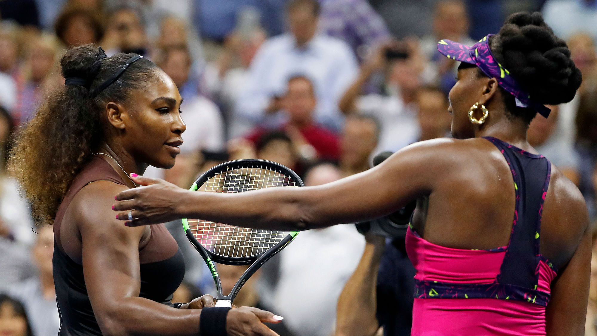 Serena Williams, left, meets her sister Venus Williams after their match during the third round of the US Open.