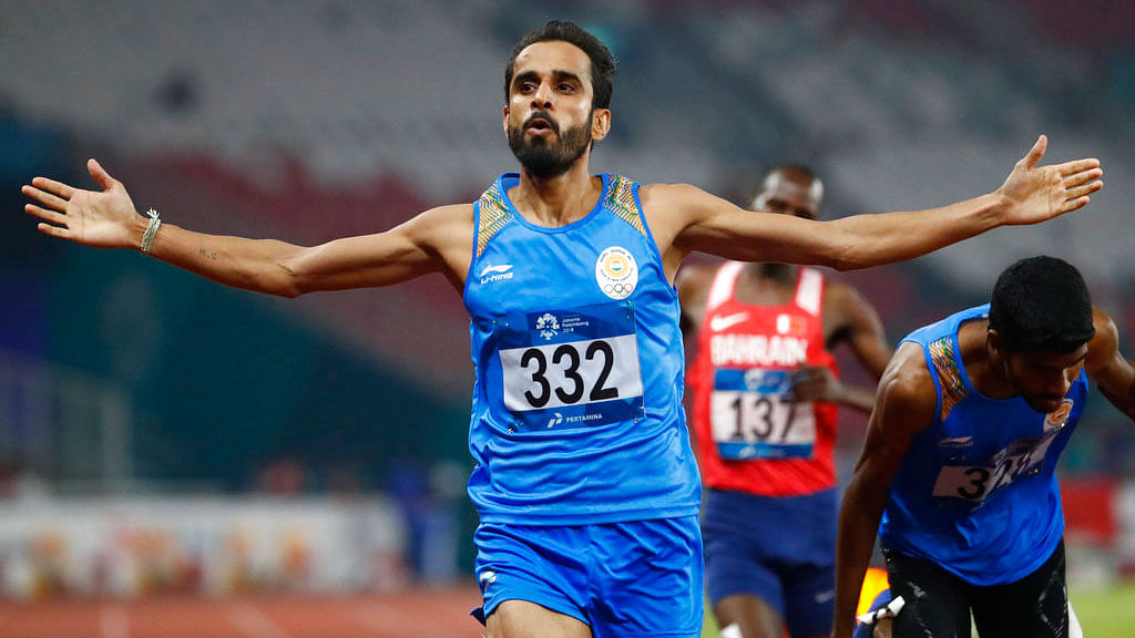 Manjit Singh celebrates as he crosses the finish line to win the 800m final at the Asian Games.