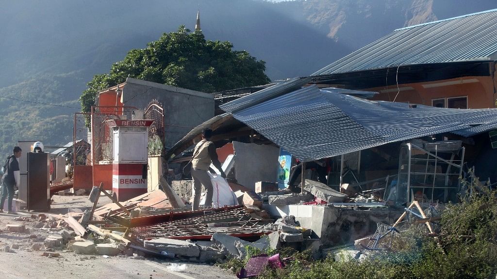People inspect buildings damaged by earthquake in Sembalun, on Lombok Island, Indonesia.
