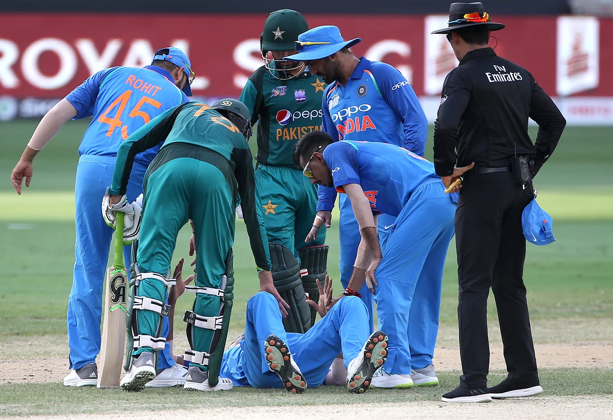 Indian and Pakistani players check on India’s Hardik Pandya, on ground, after he fell during the one day international cricket match of Asia Cup between India and Pakistan in Dubai, United Arab Emirates, Wednesday, Sept. 19, 2018. 