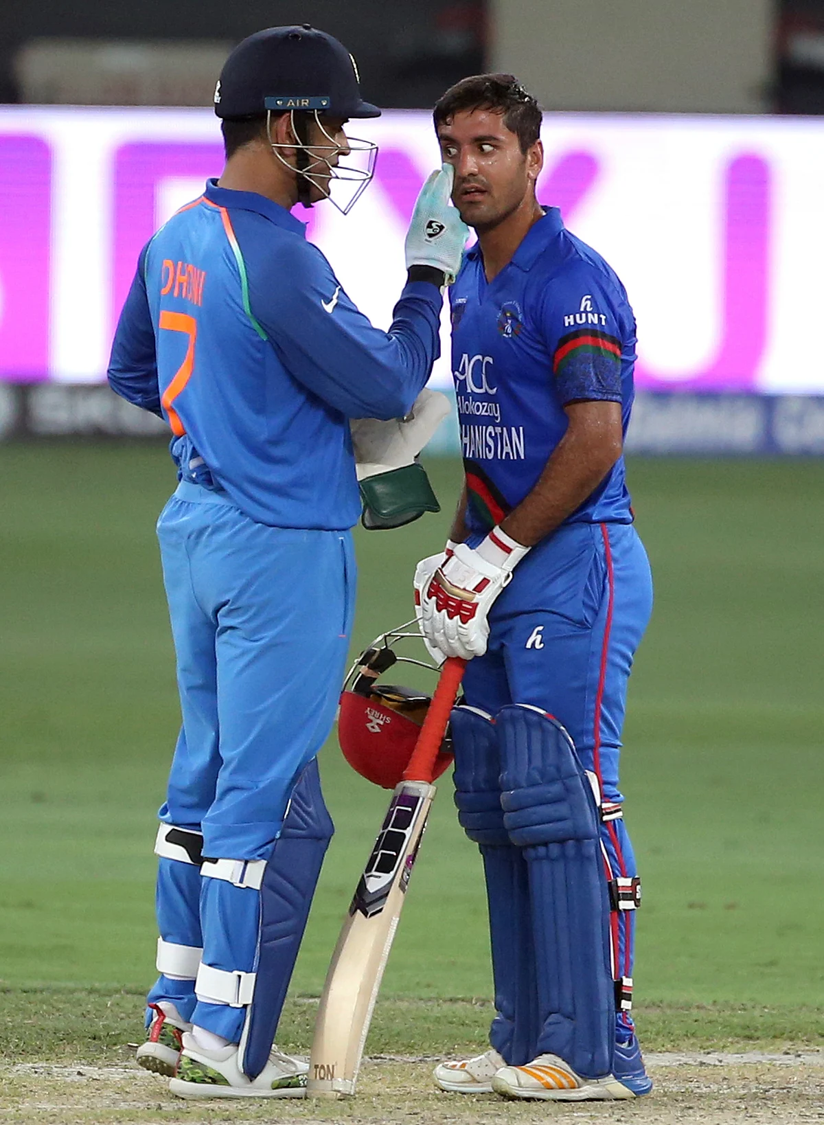 India’s Mahendra Singh Dhoni, left, checks the eye of Afghanistan’s Najibullah Zadran during the one day international cricket match of Asia Cup between India and Afghanistan in Dubai.