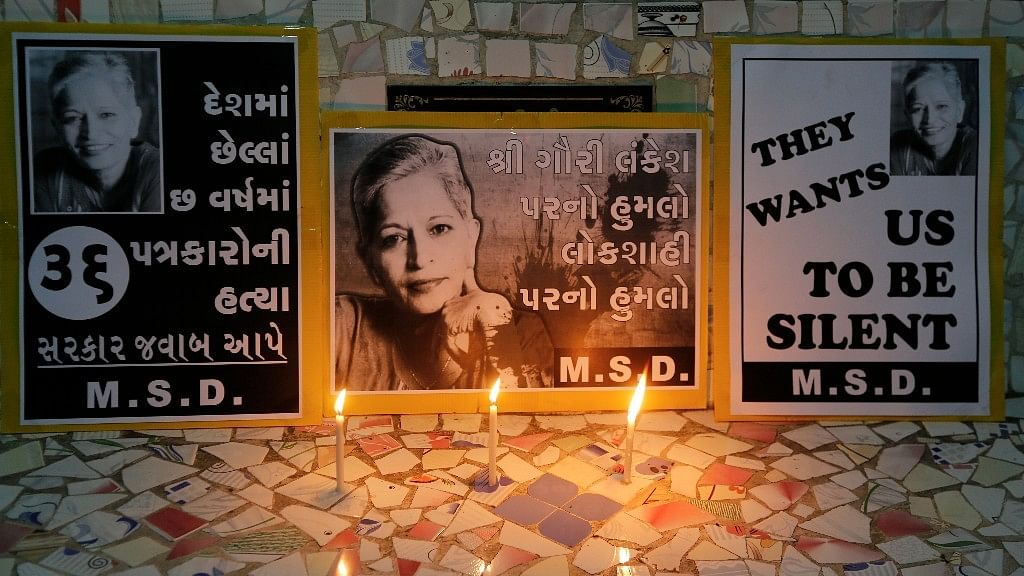 Candles burn in front of placards during a protest condemning the killing of Indian journalist Gauri Lankesh in Ahmedabad.