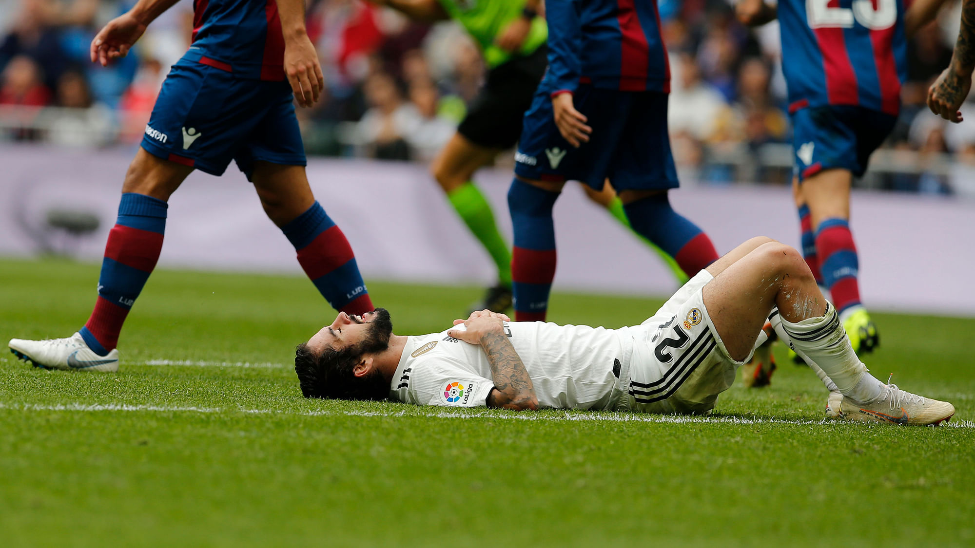 Real Madrid’s Isco lies on the ground during a Spanish La Liga soccer match between Real Madrid and Levante at the Santiago Bernabeu stadium in Madrid, Spain.