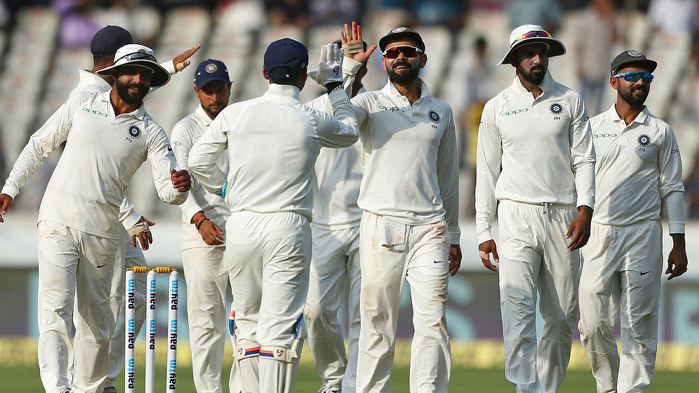 Virat Kohli celebrates a wicket with his teammates.