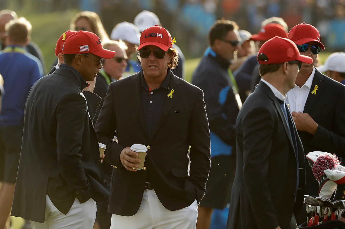 Tiger Woods of the US, left, and Phil Mickelson of the US wait for the closing ceremony after Europe won the Ryder Cup.