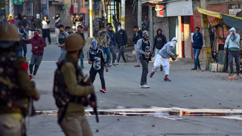 Protesters pelt stones at the police during a clash, in Srinagar on 21 October. The protest was over the death of seven civilians in the Kulgam blast.