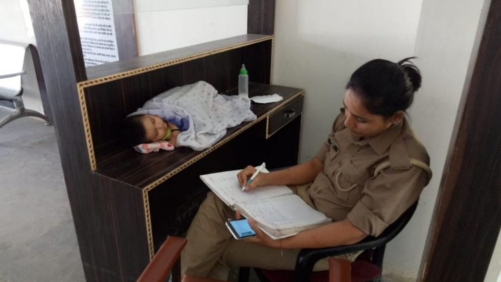 Constable Archana Jayant Singh discharging her duty at Jhansi City kotwali with her six-month-old daughter lying by her side.
