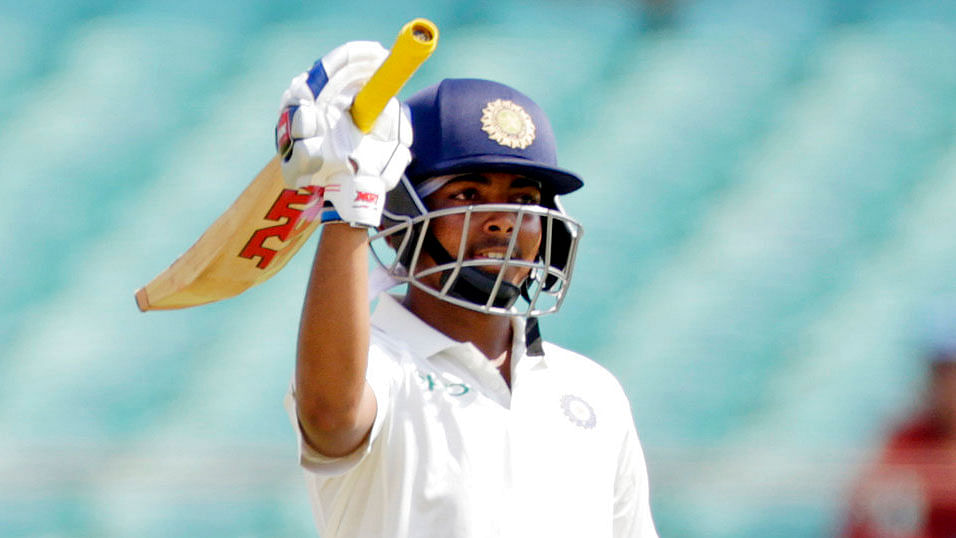 Prithvi Shaw raises his bat after scoring a half-century during a Test match.