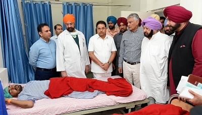 Amritsar: Punjab Chief Minister Captain Amarinder Singh, state Cabinet Minister Navjot Singh Sidhu and state Congress President Sunil Jakhar meet an accident victim at Civil Hospital after a local train crushed at least 58 people and left 72 injured while watching the burning of a Ravana effigy from a railway track last night; in Amritsar on Oct 20, 2018. (Photo: IANS)