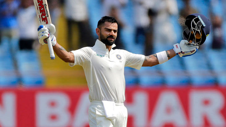 Virat Kohli raises his bat after scoring a century on Day 2 of the first Test against West Indies.