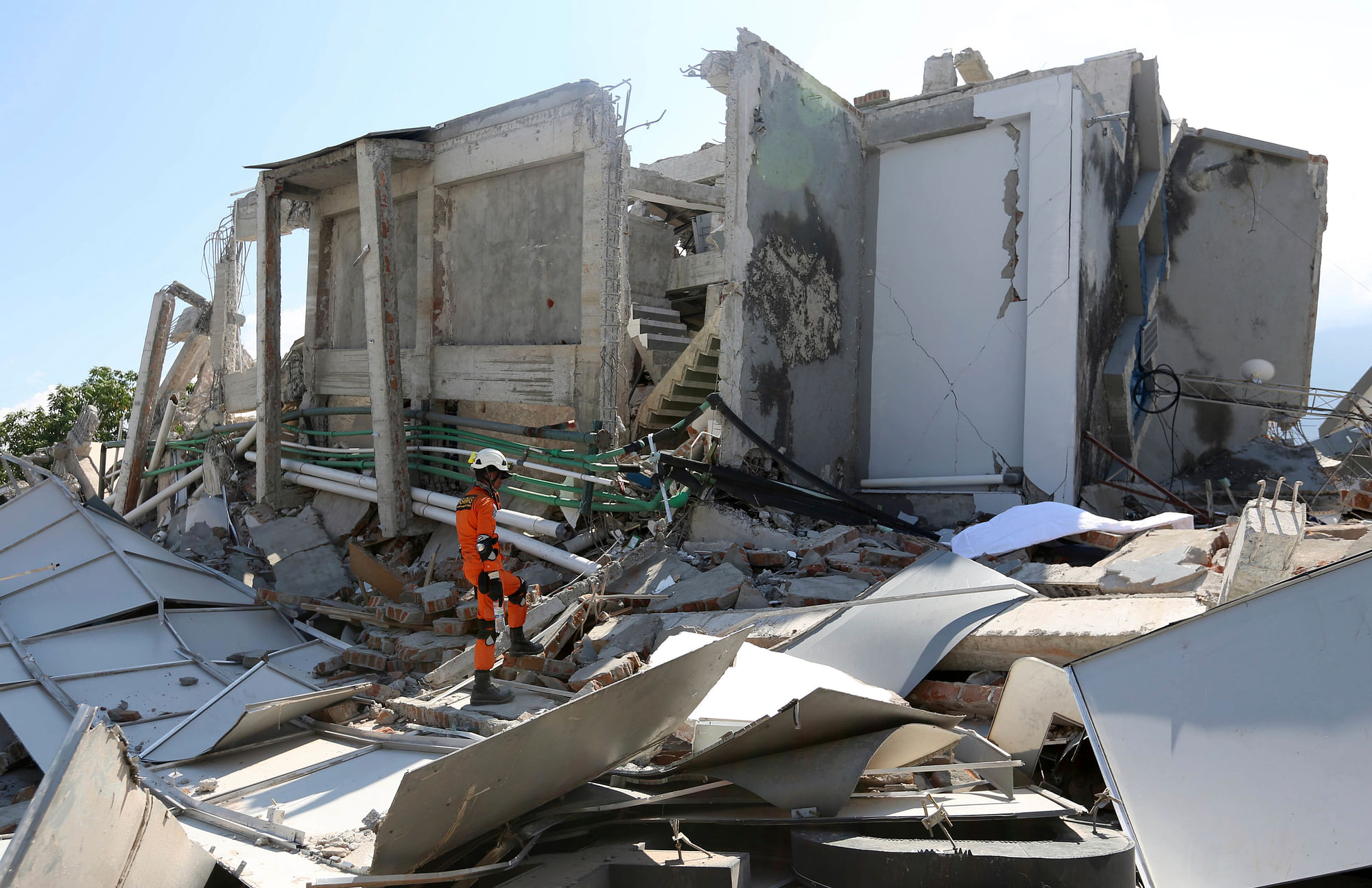 A rescuer inspects the damage of Roa-Roa Hotel following a massive earthquake and tsunami in Palu.