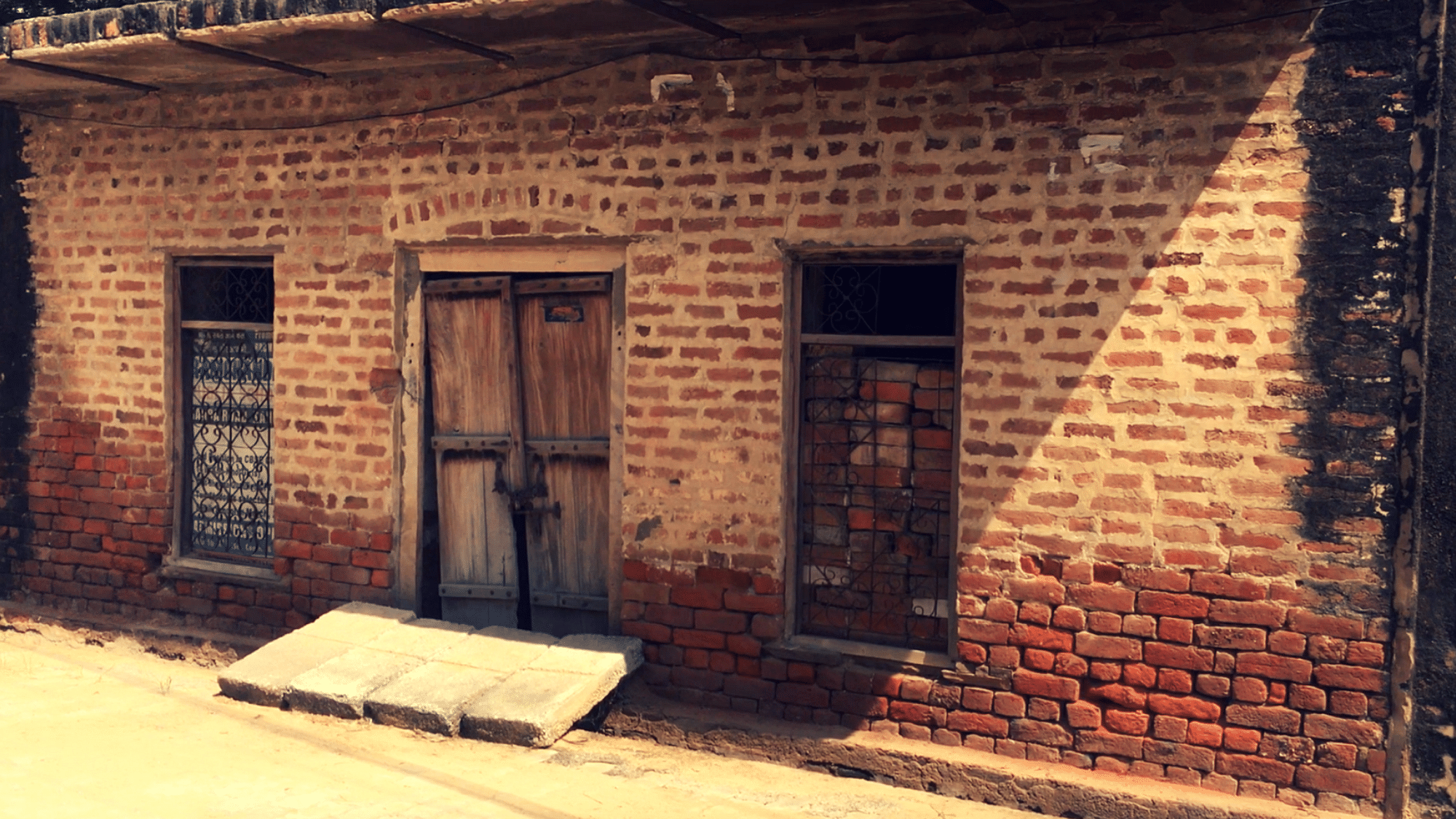 An image of a locked brick home in the Rewari survivor’s village.