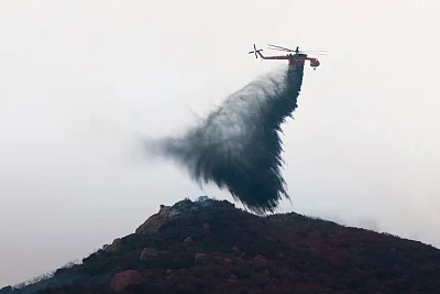 THOUSAND OAKS , Nov. 14, 2018 (Xinhua) -- A helicopter drops water on wildfires in Thousand Oaks, California of the United States, on Nov. 13, 2018. The fire in Southern California continued to destroy homes. (Xinhua/Qian Weizhong/IANS)