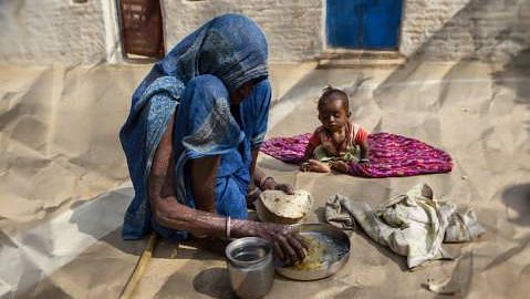 A woman eating chapatis and dal in the village of Lar Sauryana in Tikamgarh, Madhya Pradesh.
