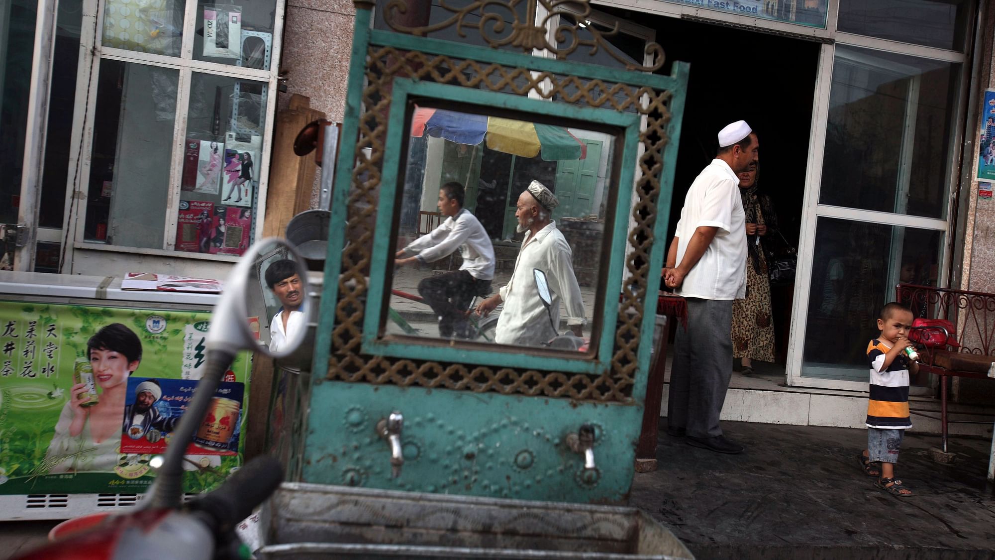 Uighurs are seen outside a restaurant in Kashgar in China’s western Xinjiang province. More than a million Chinese civil servants have been assigned to move into the homes of Uighurs and other ethnic minorities, spending weeks as uninvited guests. 