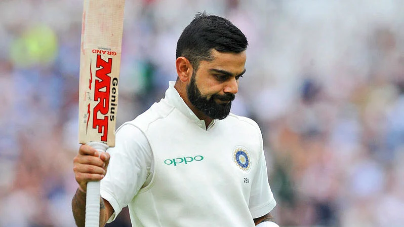 Virat Kohli raises his bat after scoring a century.