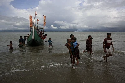 Dakhinpara: Rohingya refugees arrive at Shah Porir Dwip in Dakhinpara ofBangladesh from Rasidong in Myanmar, on Sept 13, 2017. (Photo: bdnews24/IANS)