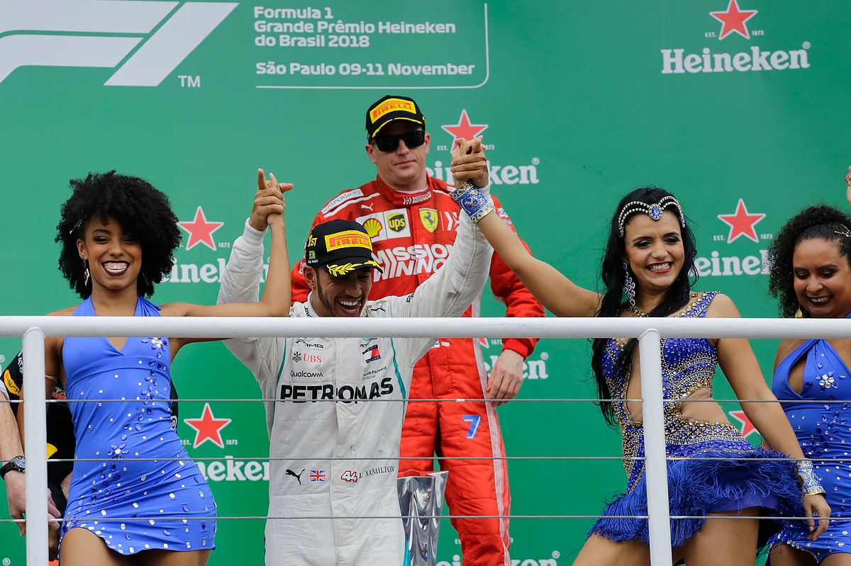 Lewis Hamilton rejoices at the podium in Sao Paulo as Kimi Raikkonen looks on