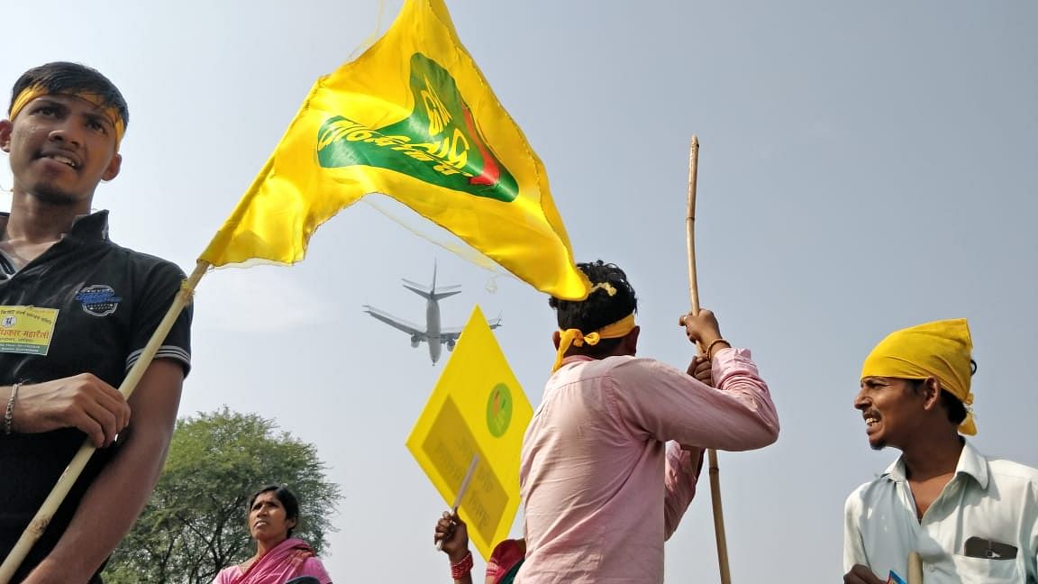 An airplane passes by as protesters take rest in Delhi’s Mahipalpur, on the way to the Ramlila grounds.