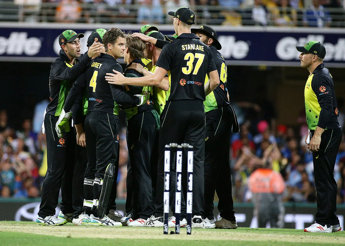 Australian players congratulate Adam Zampa (center, back-to-camera) after he dismissed KL Rahul