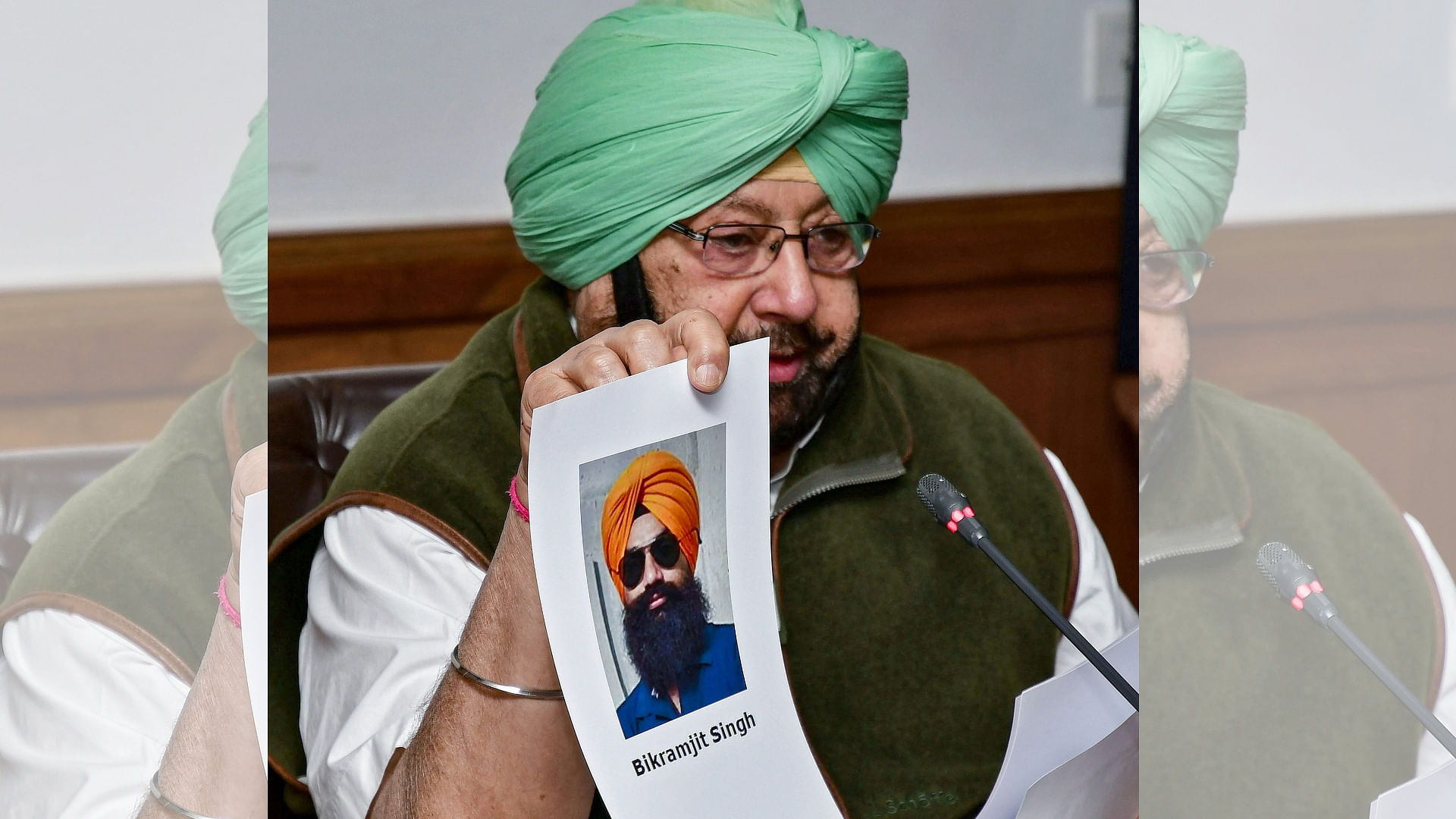 Punjab Chief Minister Capt. Amarinder Singh shows a picture of Amritsar grenade blast co-accused Bikramjit Singh to the media during a press conference in Chandigarh.