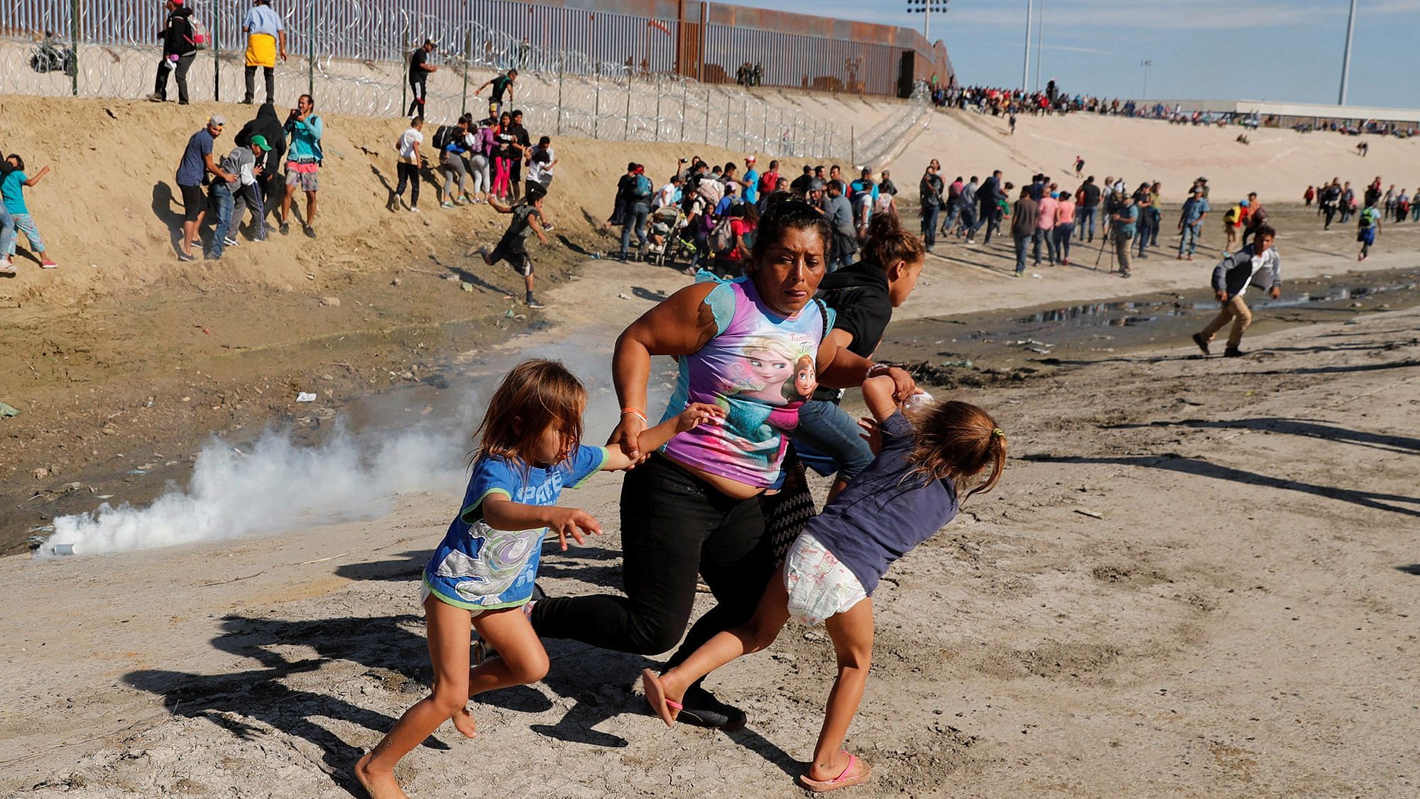 A migrant family runs away from the tear gas attack