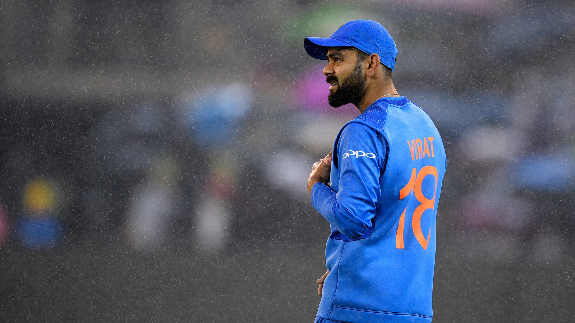 India’s Virat Kohli watches play as the rain falls during the Twenty20 international cricket match between India and Australia in Melbourne, Australia.