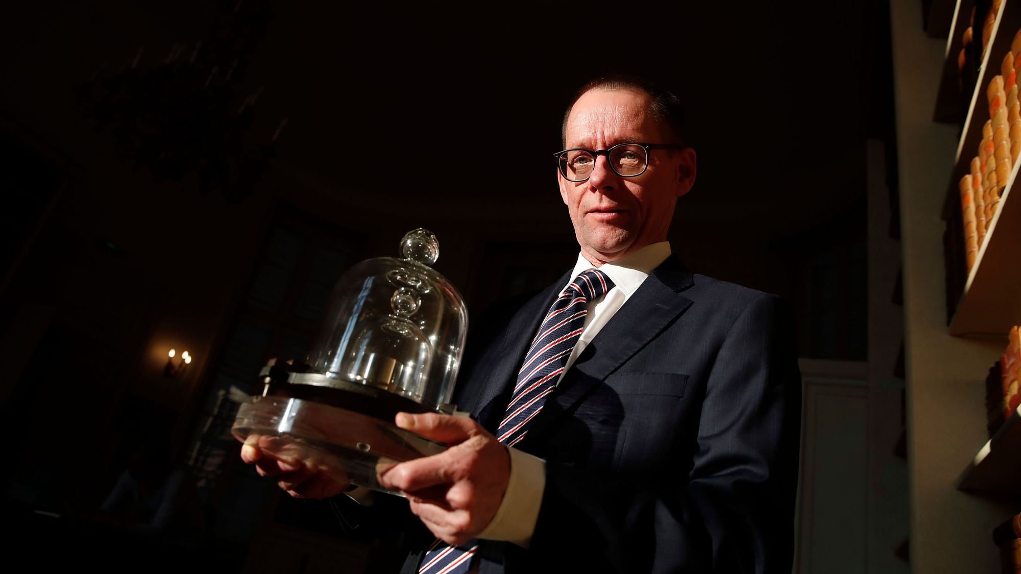The head of BIPM (International Bureau of Weights and Measures) Martin JT Milton holds a replica of the International Prototype Kilogram in Sevres, near Paris.