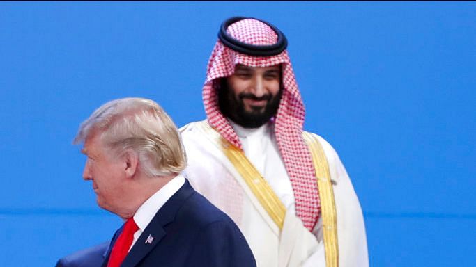 Saudi Arabia’s Crown Prince Mohammed bin Salman, back, stands as President Donald Trump passes by while leaders gather for the family photo of the G20 summit.