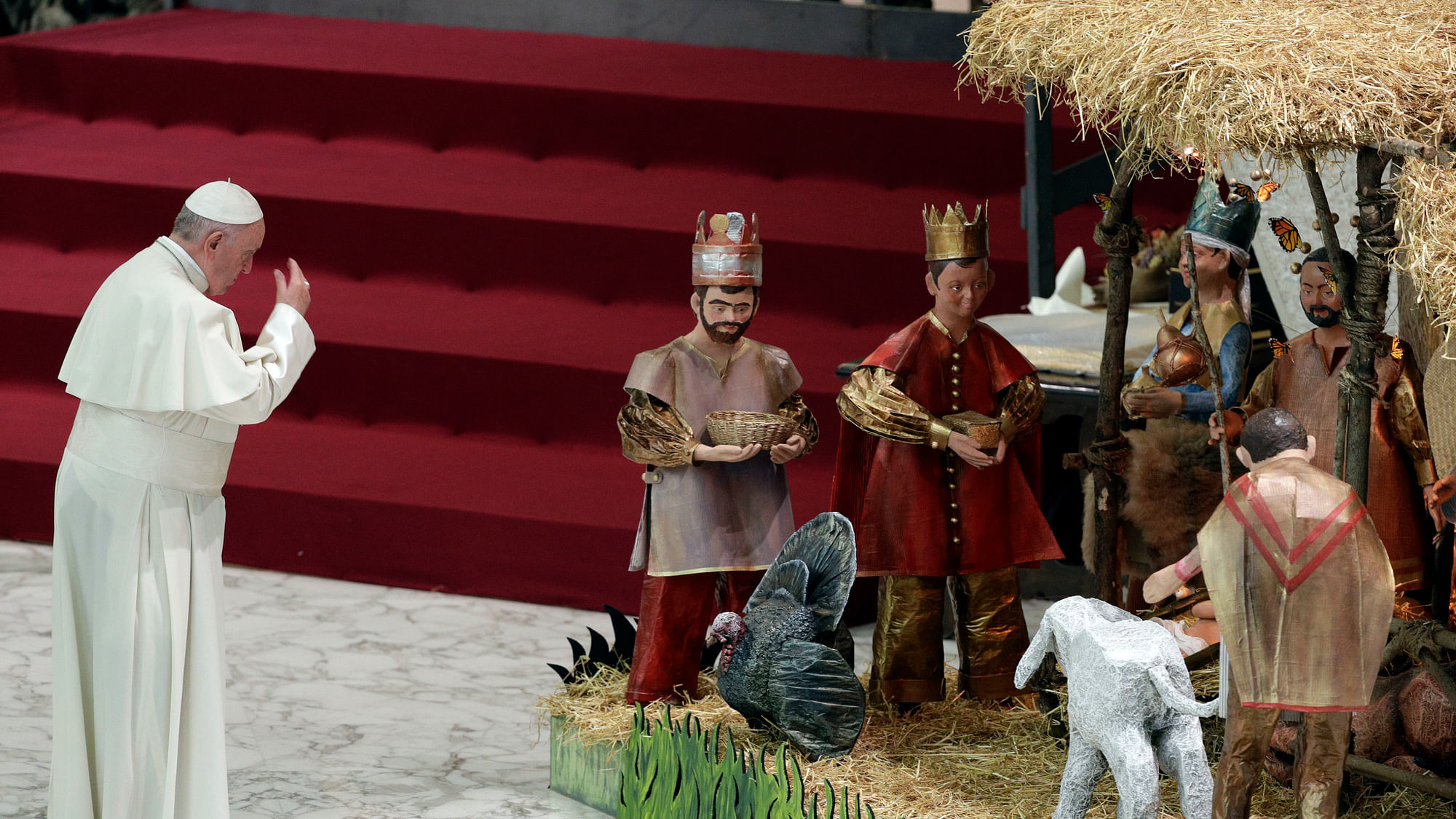 Pope Francis prays in front of a Nativity scene on the occasion of his weekly general audience at the Vatican