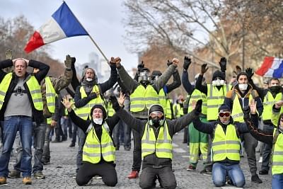PARIS, Dec. 8, 2018 (Xinhua) -- "Yellow Vests" protesters shout slogans near the Arch of Triumph in Paris, France, on Dec. 8, 2018. Riot police fired tear gas and water cannon at "Yellow Vests" protesters marching in Paris on Saturday in the fourth week-end action despite President Emmanuel Macron