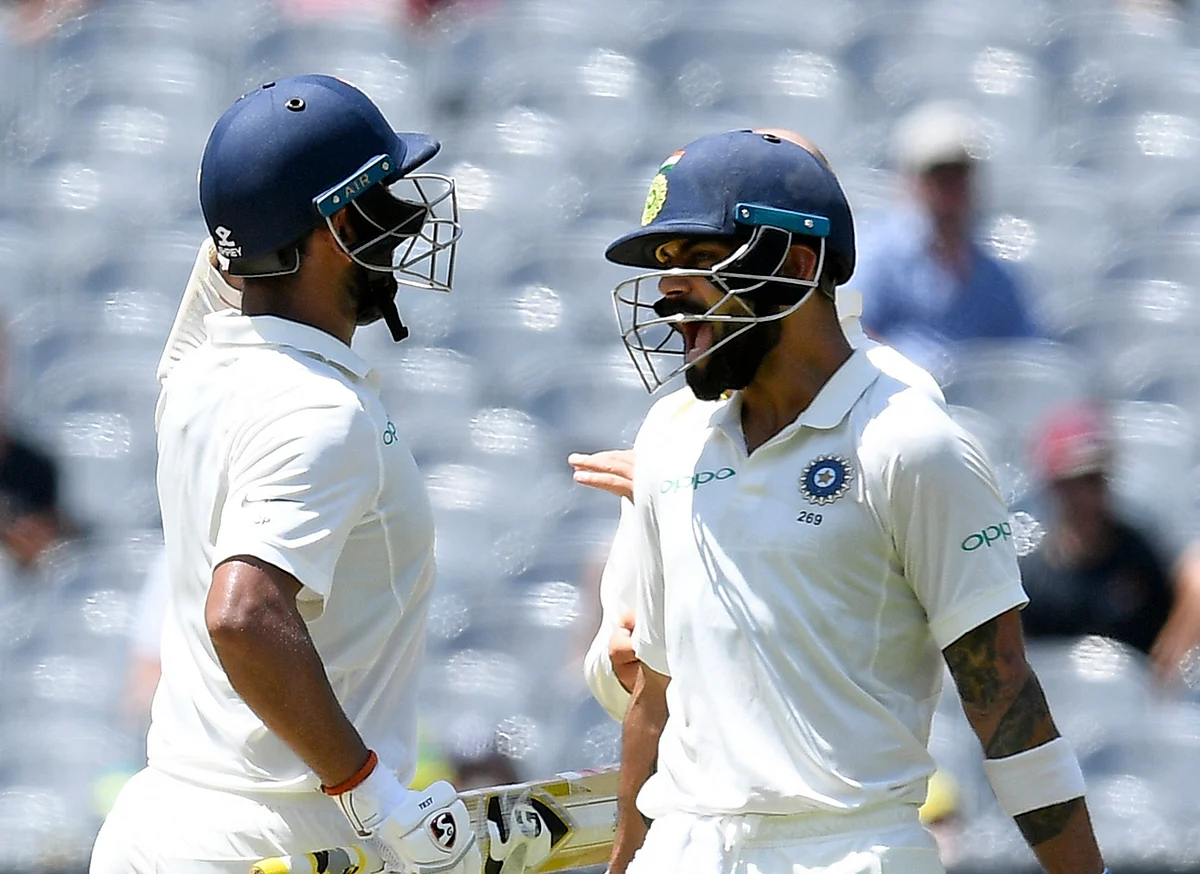 Virat Kohli celebrates Cheteshwar Pujara’s century with his team-mate.
