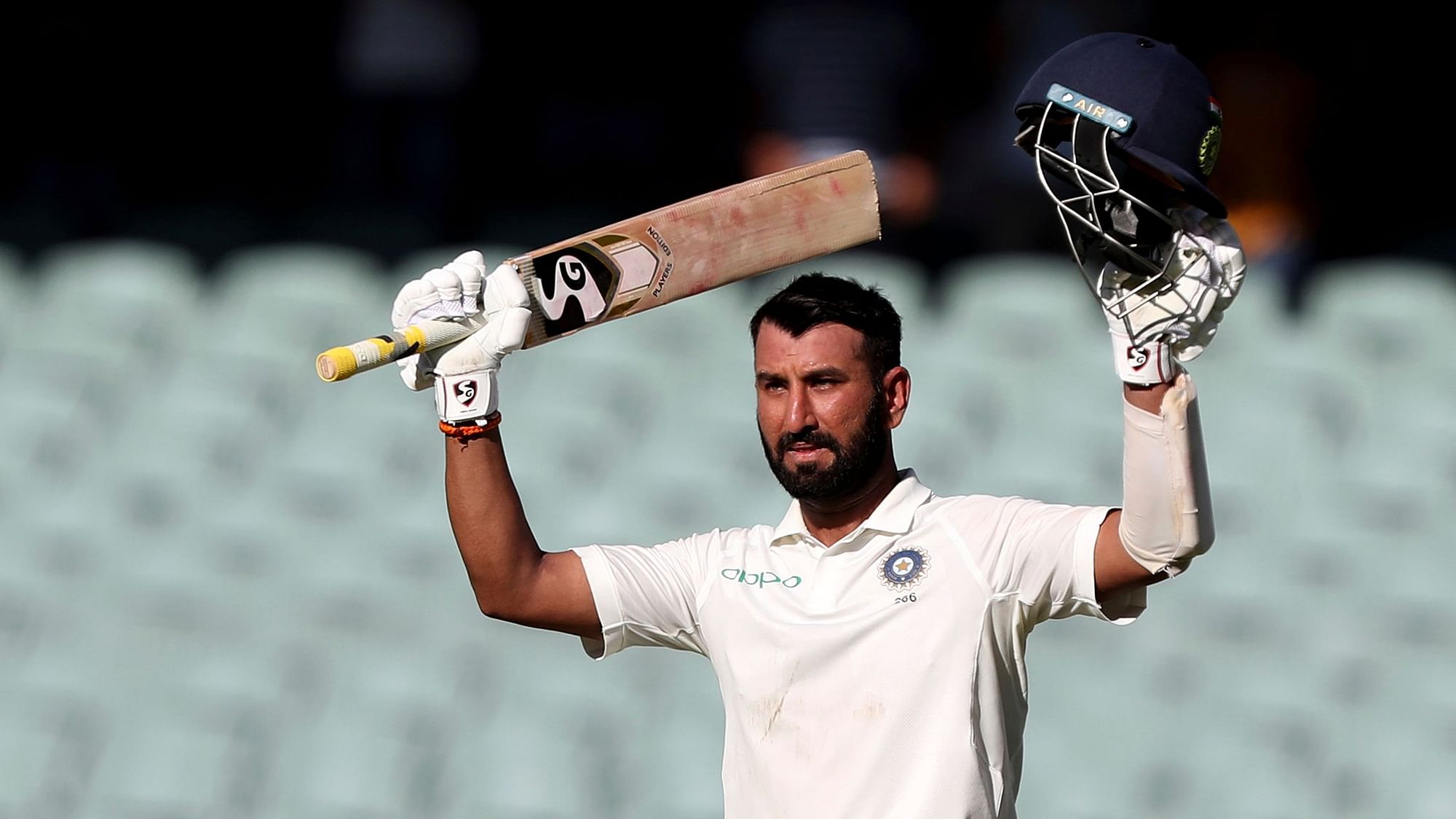 Cheteshwar Pujara celebrates after reaching a century on Day 1 of the first Test between Australia and India at Adelaide.