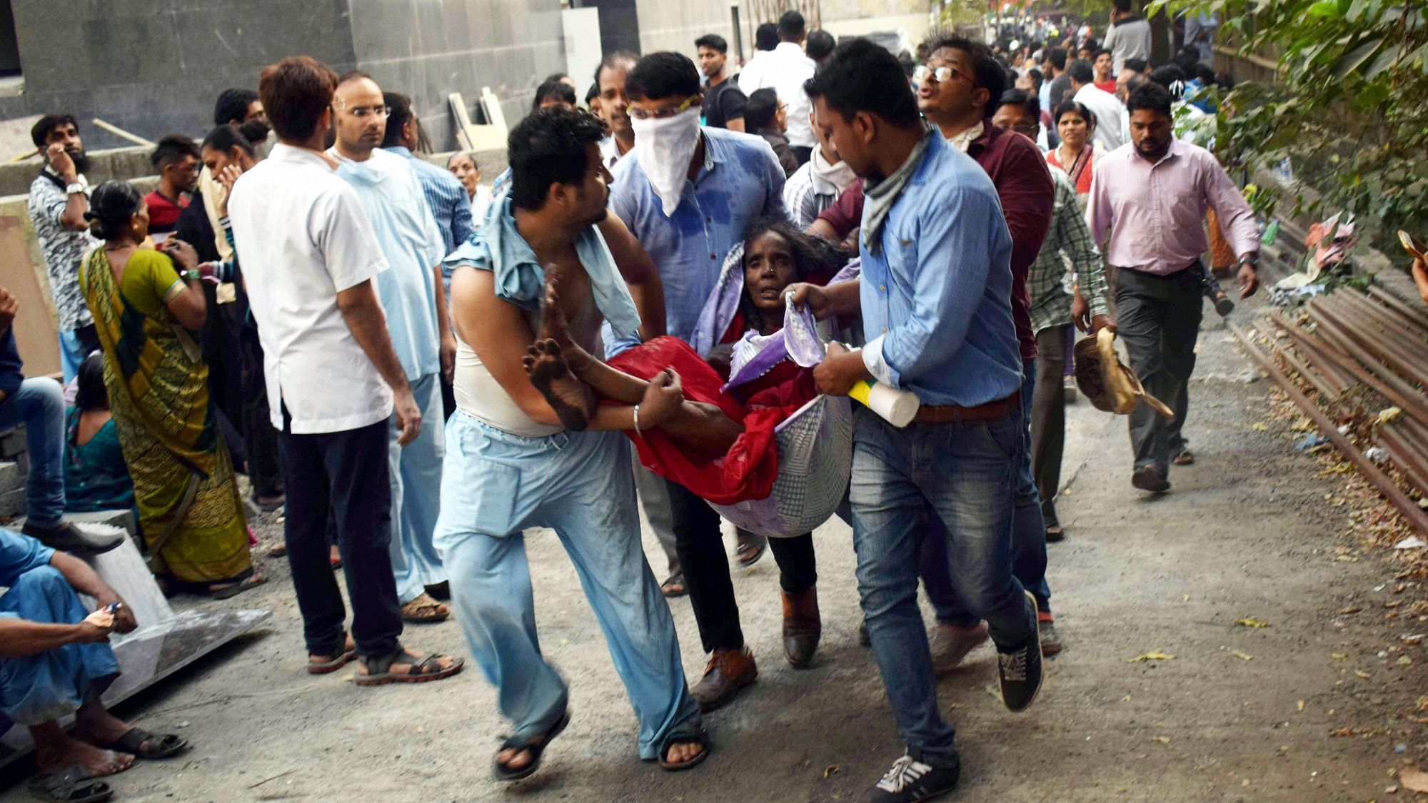 People carry the injured during a rescue operation after a major fire broke out at ESIC Kamgar Hospital, in Mumbai, on 17 December.