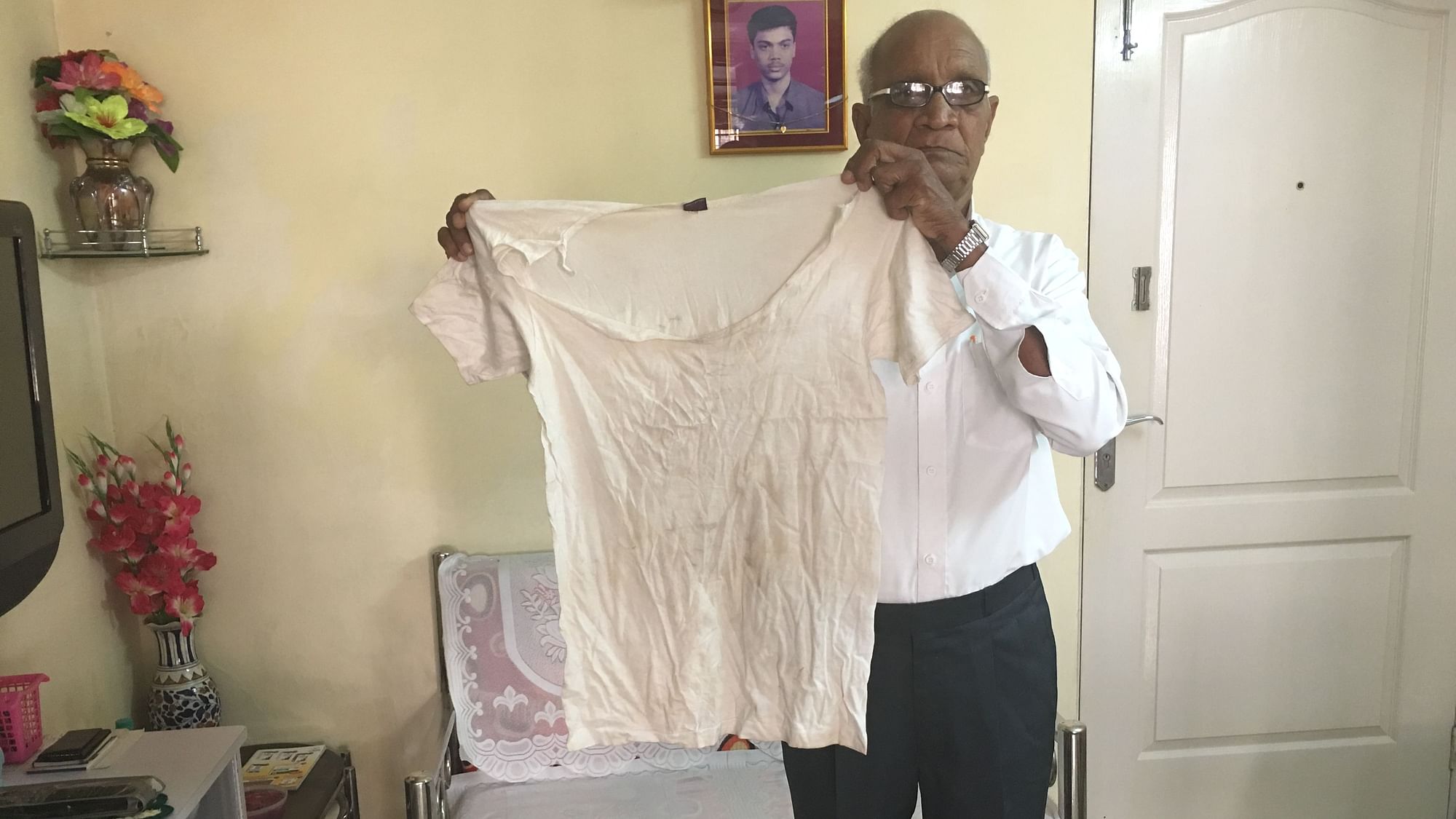 Dr Dattatray Nimje holds up the T-shirt he was wearing the day he was assaulted by the police at Wadala police station,&nbsp;