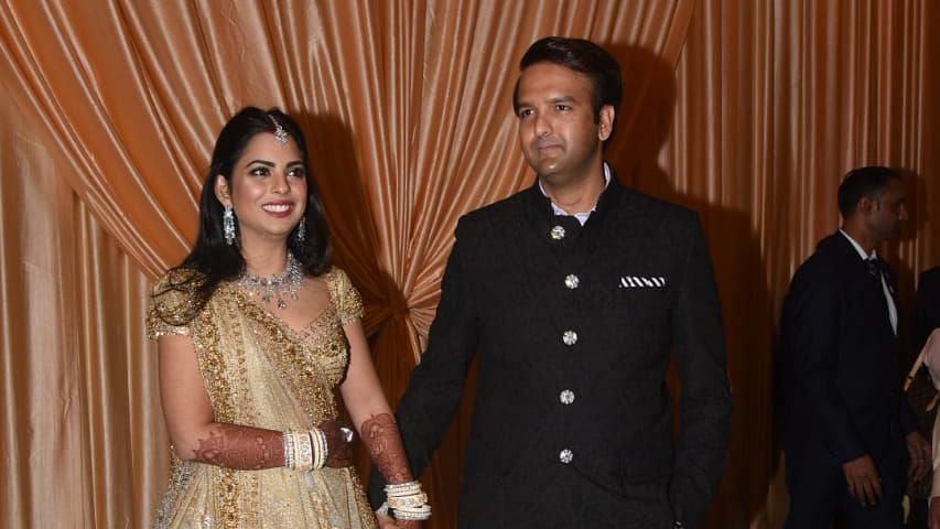 Newlyweds Isha Ambani and Anand Piramal smile at their wedding reception.