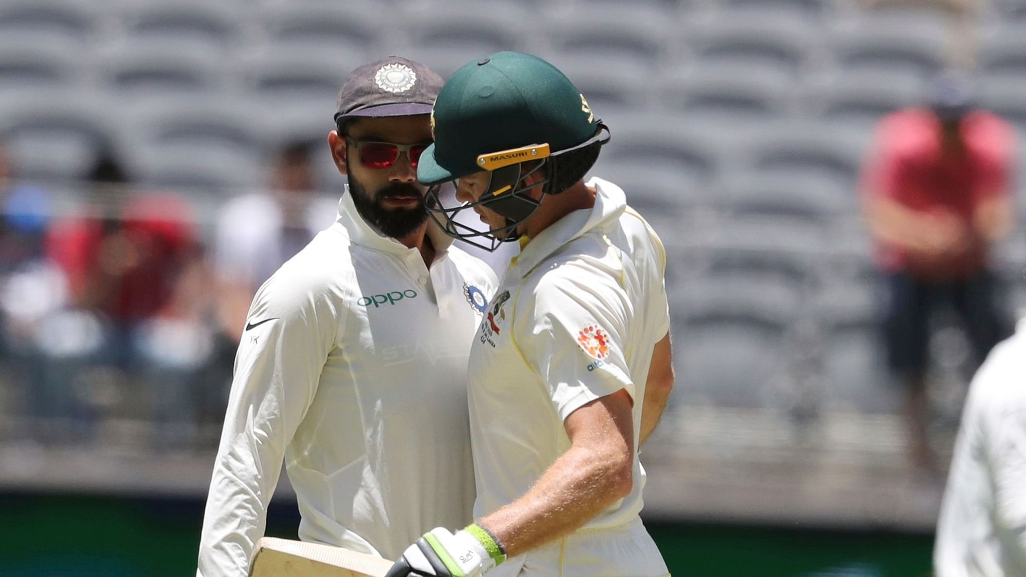 Opposing captains, India’s Virat Kohli, left, and Australia’s Tim Paine come face to face during play in the second cricket Test between Australia and India
