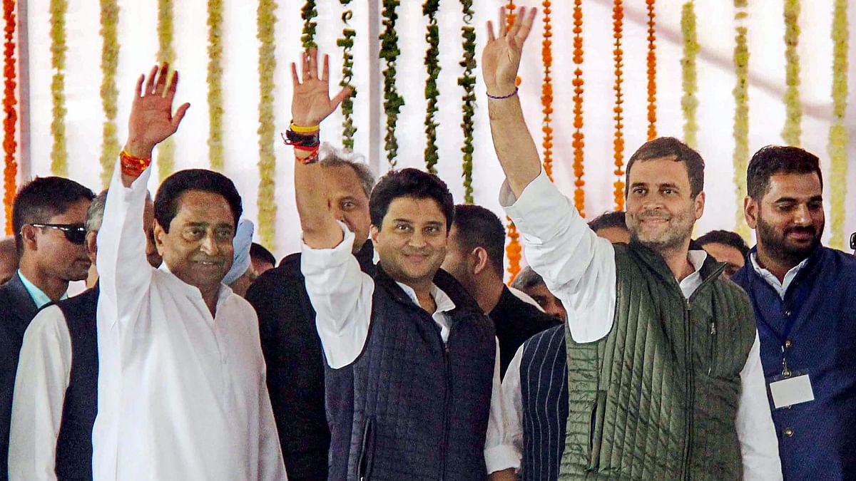 President Rahul Gandhi (R) with newly-sworn in Madhya Pradesh Chief Minister Kamal Nath (L) and party MP Jyotiraditya Scindia wave at the crowd during swearing-in-ceremony.