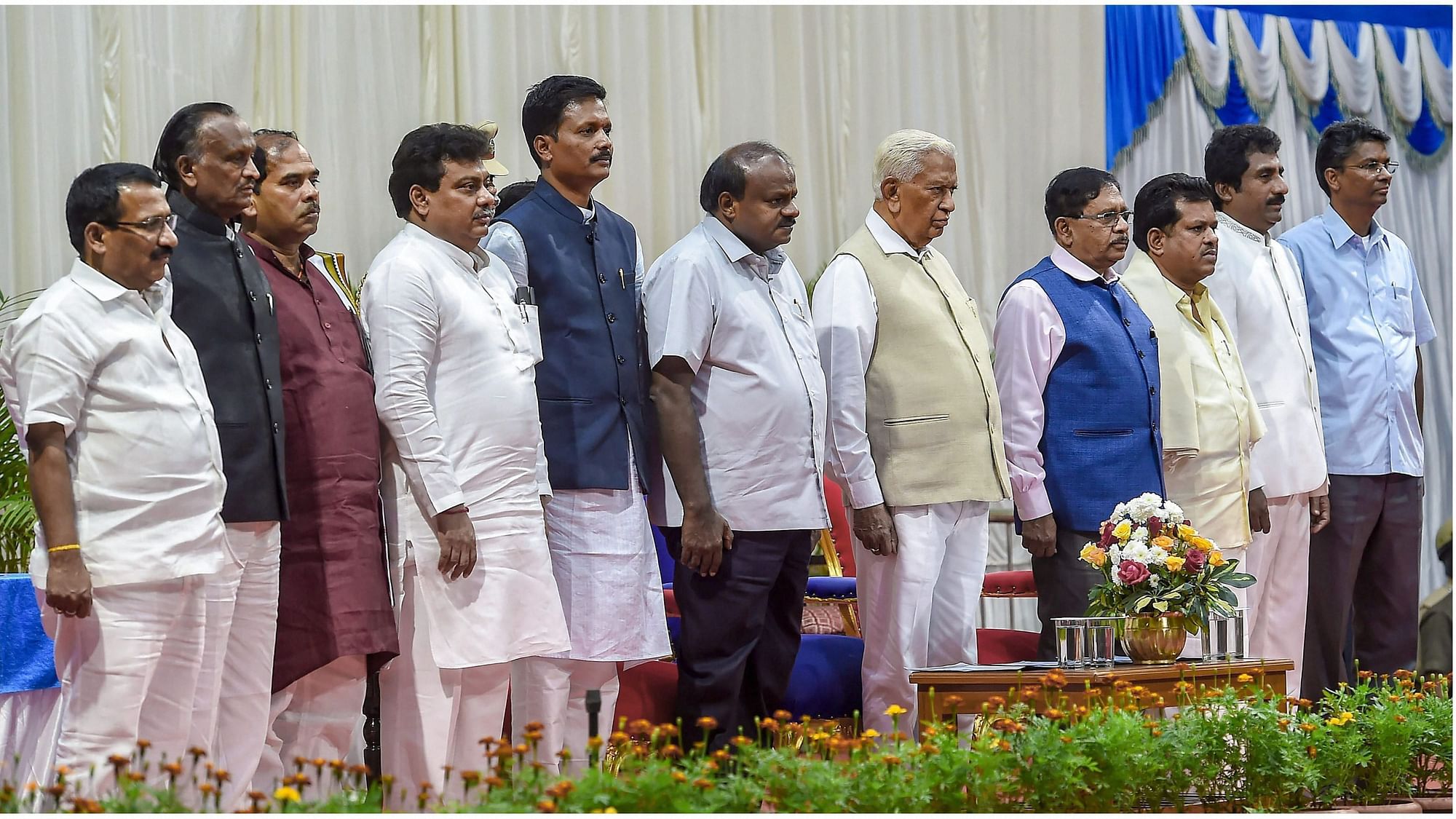 Karnataka Governor Vajubhai Vala (centre), Chief Minister HD Kumaraswamy, Deputy CM G Parameshwara with newly inducted ministers during the swearing-in ceremony for the Cabinet expansion of coalition government of Congress-JD(S), in Bengaluru, on 22 December.