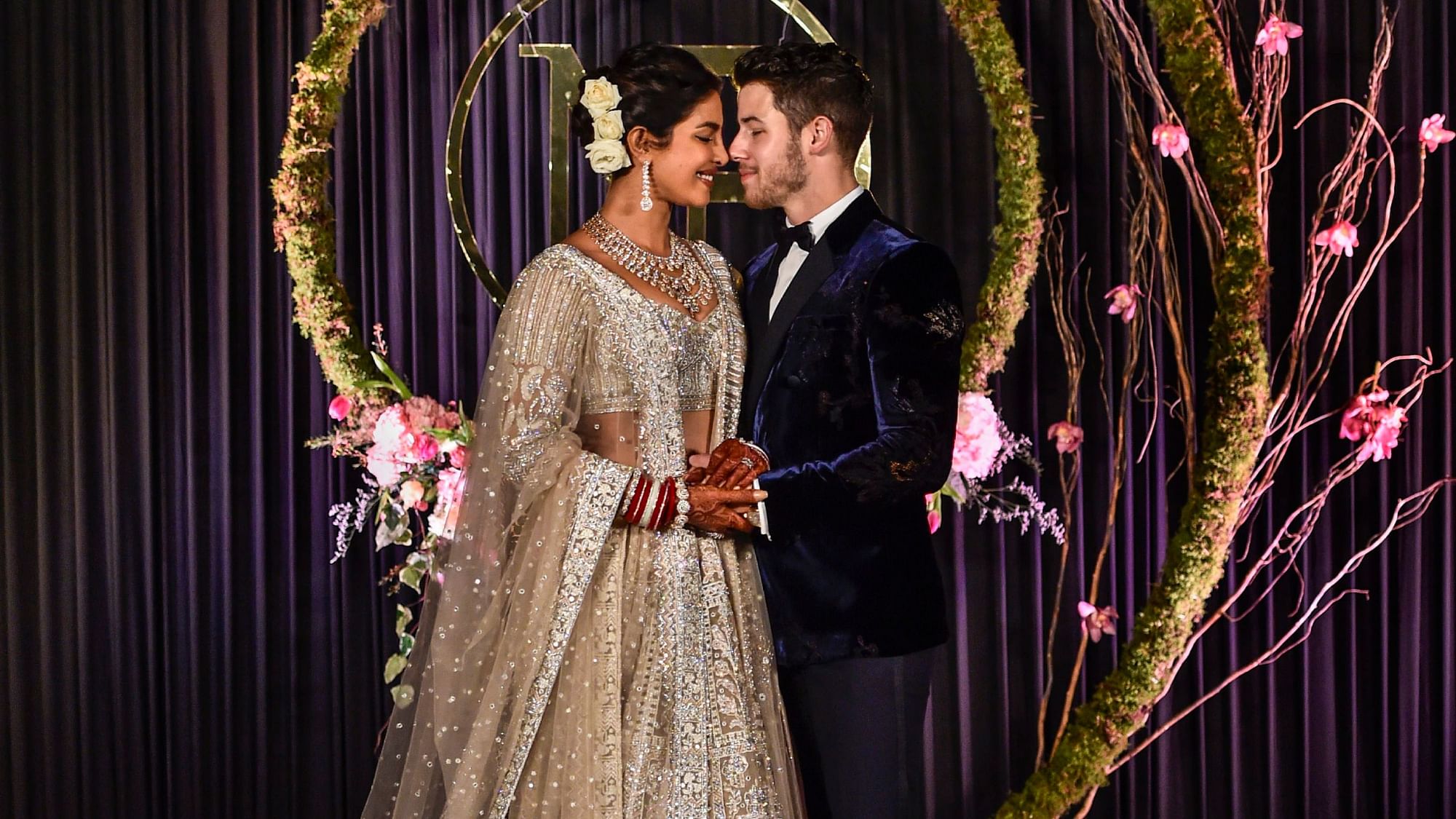 Newly-wed Bollywood actor Priyanka Chopra and American singer Nick Jonas pose for photos during their wedding reception, in New Delhi, Tuesday, Dec. 4, 2018.